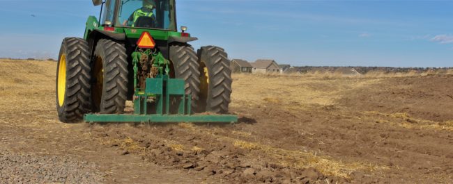 Tractor prepares soil for native grass seeding