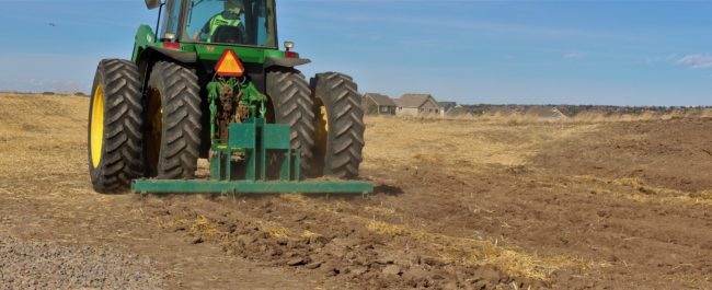 Tractor prepares soil for native grass seeding