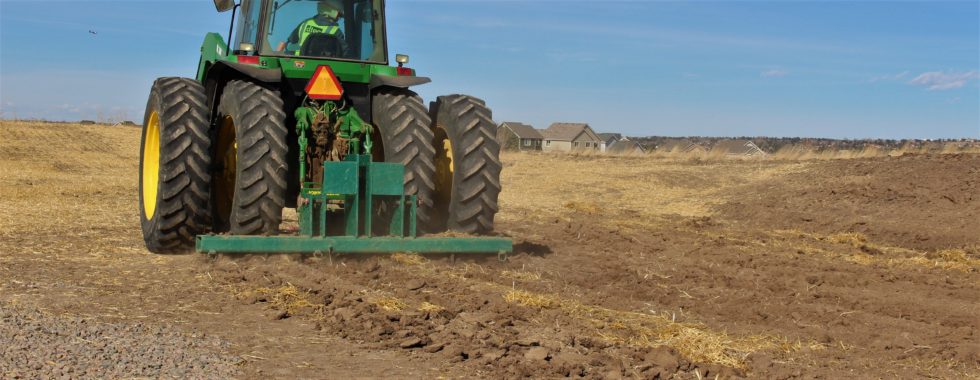 Tractor prepares soil for native grass seeding